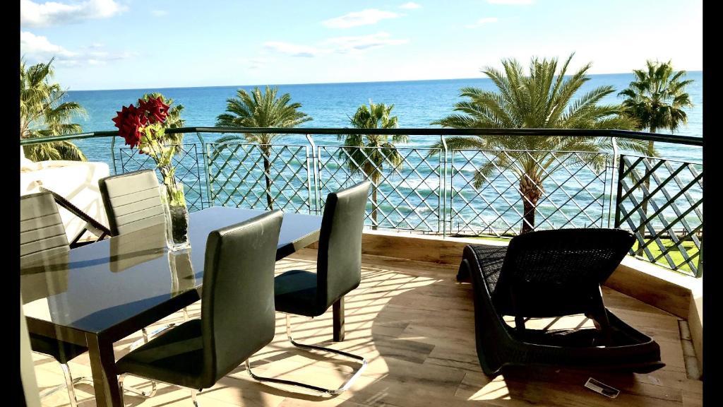 uma varanda com uma mesa e cadeiras e o oceano em MI CAPRICHO A17 Beachfront Apartment em La Cala de Mijas