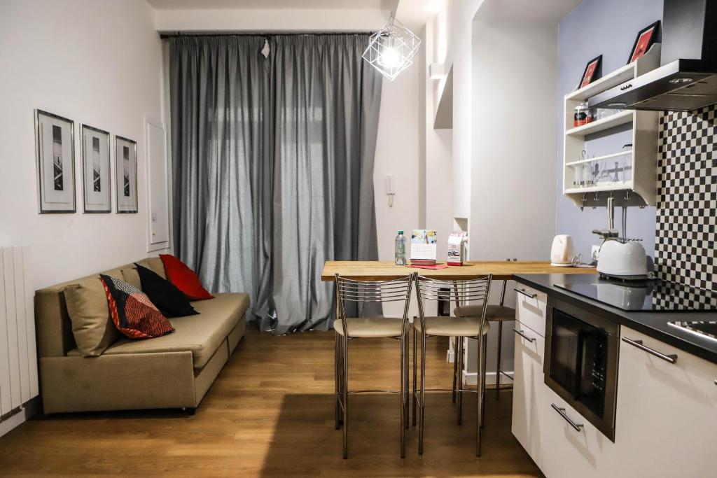 eine Küche und ein Wohnzimmer mit einem Sofa und einem Tisch in der Unterkunft Il Loggiato by Wonderful Italy in Neapel