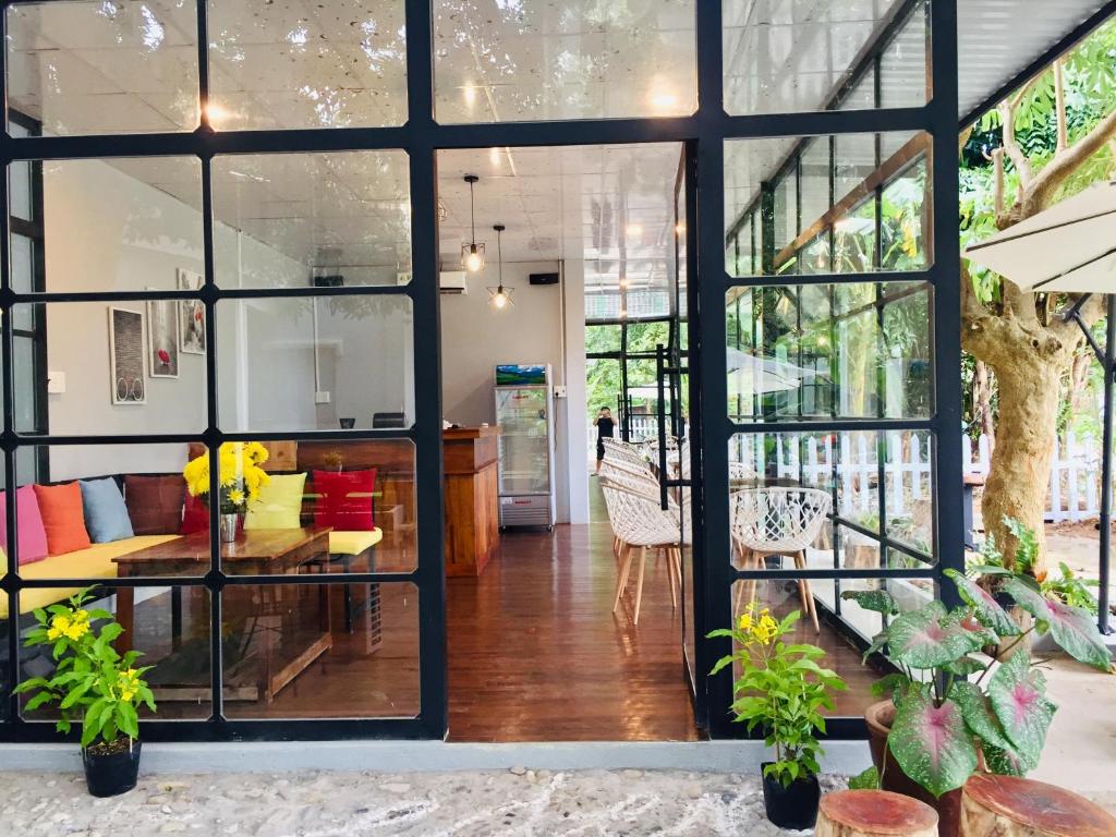 a room with large windows and a table and chairs at Eden House & Coffee Con Dao in Con Dao