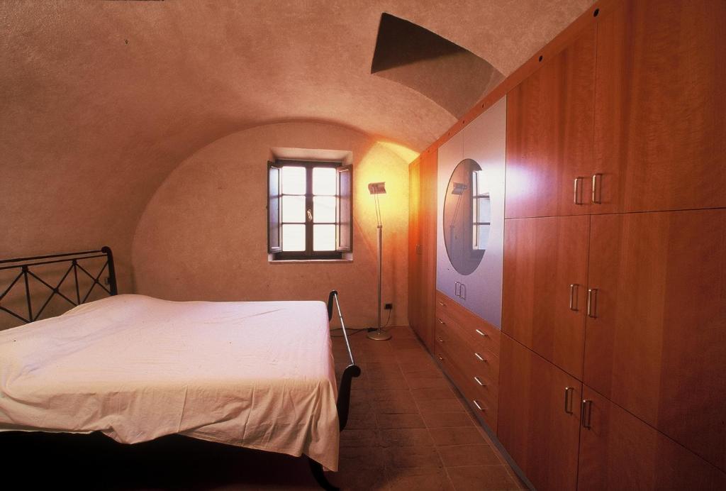 a bedroom with a white bed and a window at La Torre in Asciano