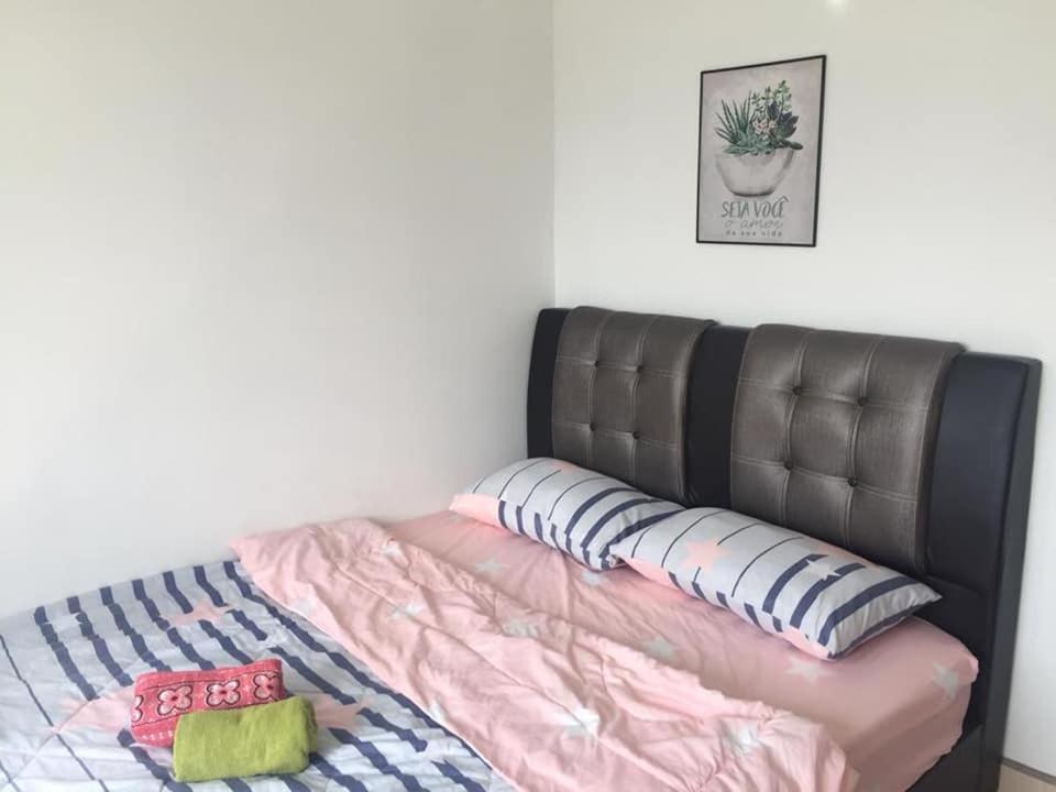 a bed with a leather headboard in a bedroom at ORKED BELLINA, 3 Bedroom apartment, near Pantai Batu Burok, NETFLIXWIFIYOUTUBE in Kuala Terengganu