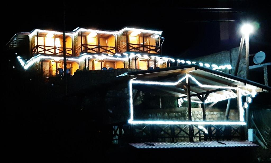 ein nachts beleuchtetes Haus mit Licht in der Unterkunft Vila Jana Mavrovo in Mavrovo-Nationalpark