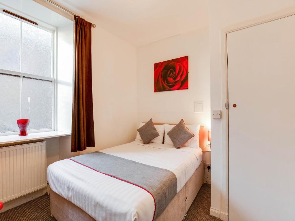 um quarto com uma cama e uma janela em Lost Guest House Peterhead em Peterhead