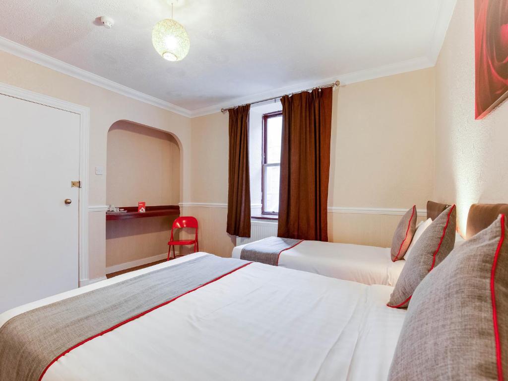 a hotel room with two beds and a window at Lost Guest House Peterhead in Peterhead