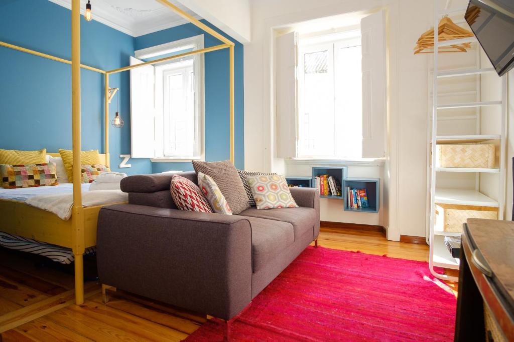 sala de estar con sofá y cama en Colourful Alfama Apartment en Lisboa