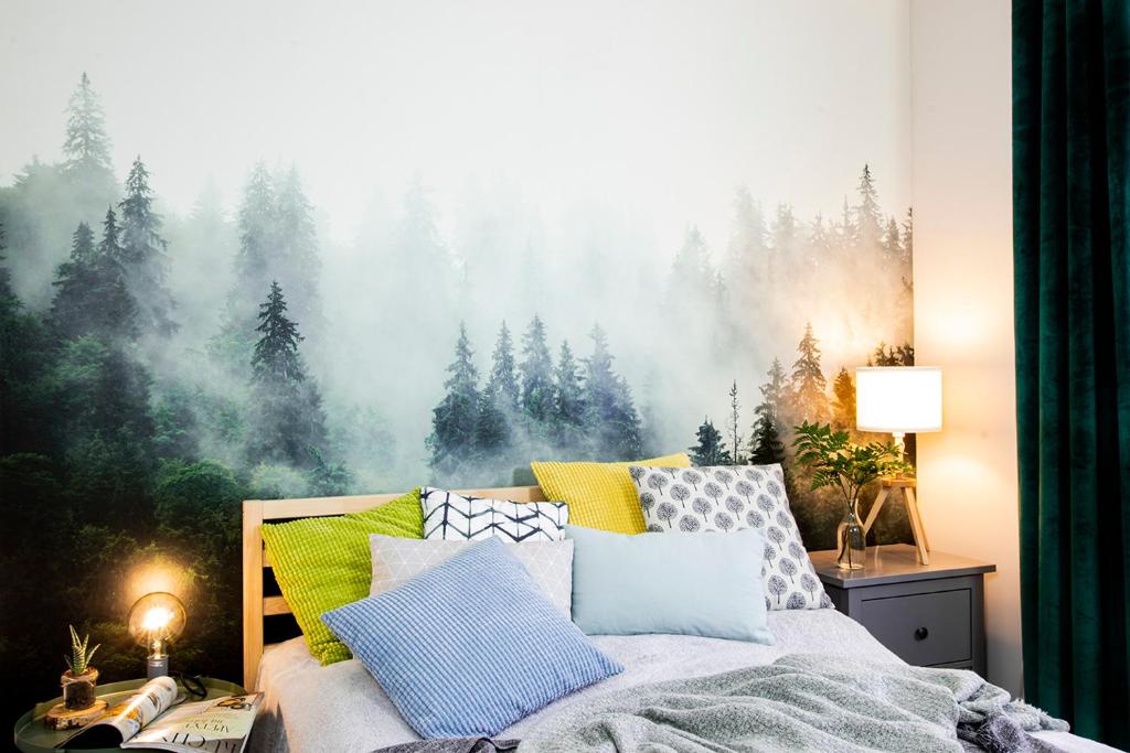 - une chambre avec un lit orné d'une peinture d'arbres dans l'établissement Apartamenty KDN Szczyrk, à Szczyrk