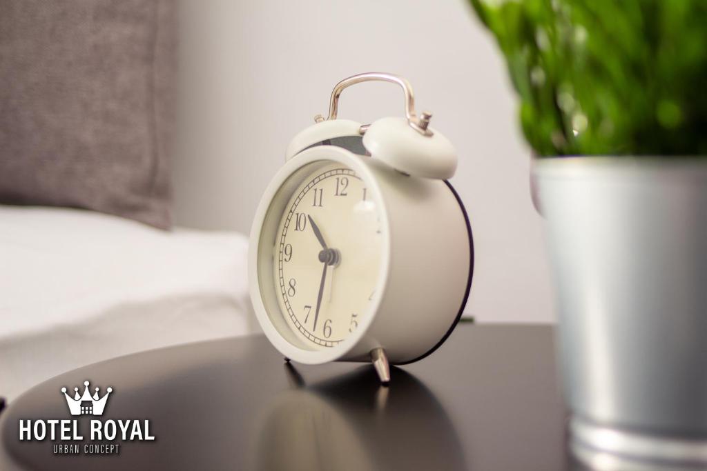 a white alarm clock sitting on top of a table at Hôtel Royal Urban Concept in Fès