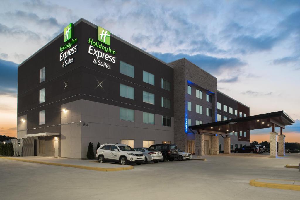 un gran edificio con coches estacionados en un estacionamiento en Holiday Inn Express & Suites Kingdom City, an IHG Hotel, en Kingdom City
