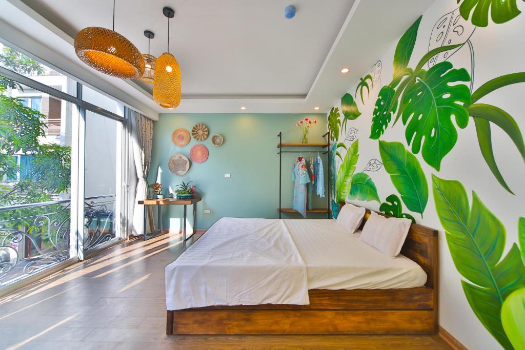 una camera da letto con un letto e un grande murale di piante di Lakeside House a Hanoi