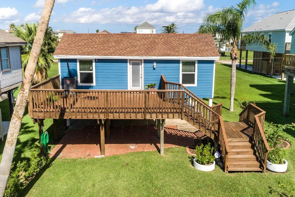 una casa con terraza de madera en el patio en Steps to Sand Galveston Beach Bungalow!, en Galveston