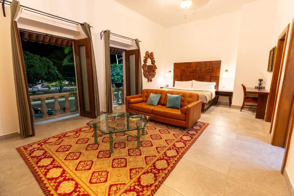 a living room with a bed and a couch and a table at Plaza Chapala Hotel in Chapala