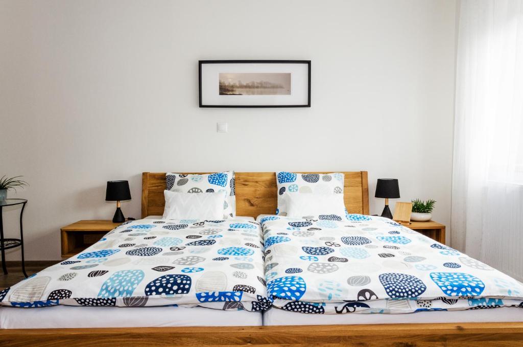 uma cama com lençóis e almofadas azuis e brancos em Apartmány u Kotačků em Veverské Knínice