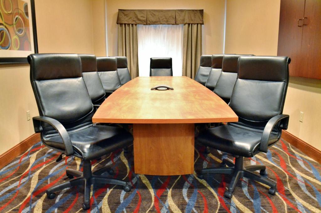 una sala de conferencias con una mesa de madera y sillas de cuero en Holiday Inn Express Hotel & Suites Center Township, an IHG Hotel, en Monaca