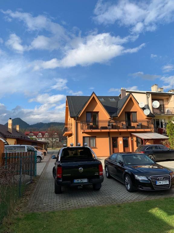 two cars parked in front of a house at Penzión Tulip in Červený Kláštor