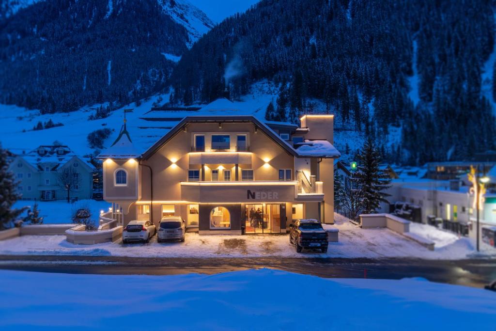 a large house in the snow at night at Hotel Neder in Ischgl