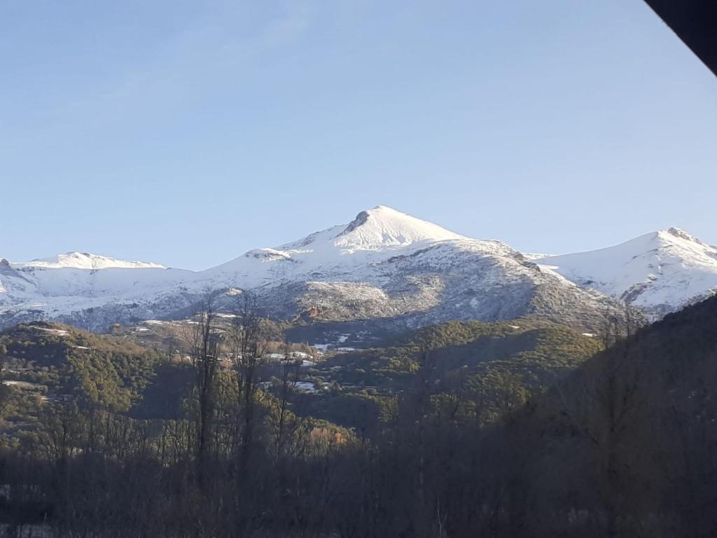 een met sneeuw bedekte berg met bomen ervoor bij Perera in Castejón de Sos