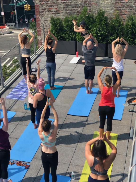 un grupo de personas haciendo yoga en la acera en Pod Brooklyn, en Brooklyn