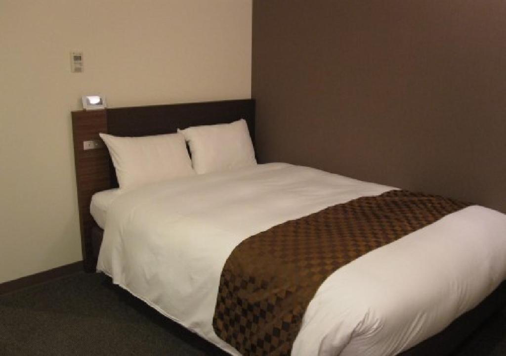 a bedroom with a large bed with white sheets at Hotel Ascent Plaza Hamamatsu / Vacation STAY 64700 in Hamamatsu