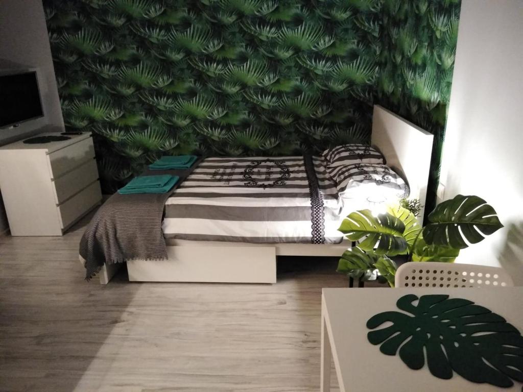 Apartament Be Happy Nr 1 في غدينيا: غرفة نوم بسرير مع جدار أخضر