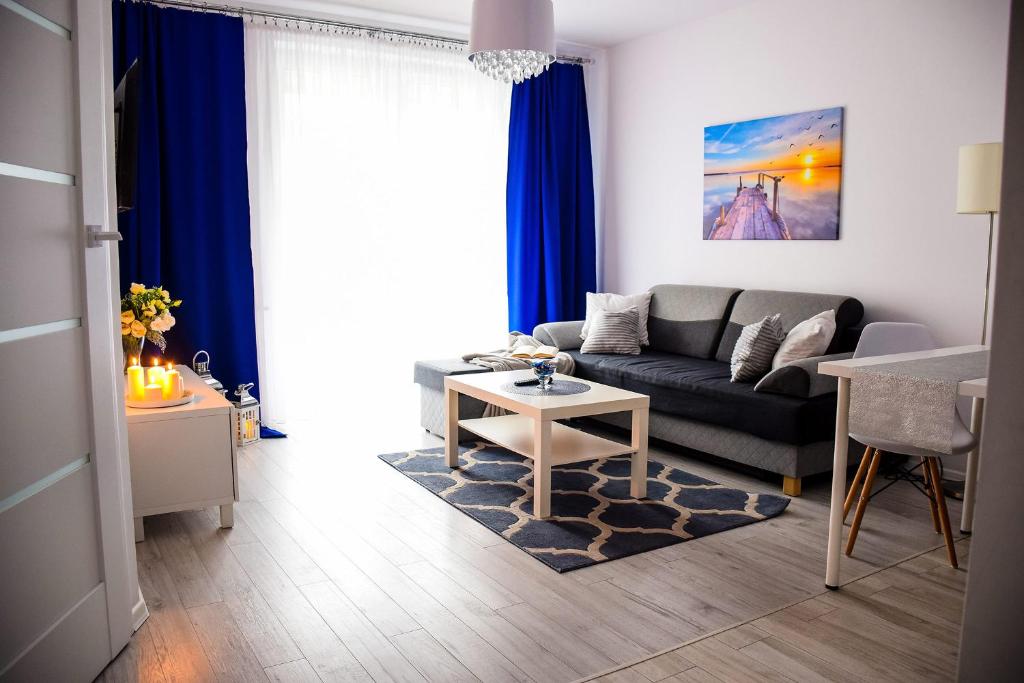 ein Wohnzimmer mit einem Sofa und einem Tisch in der Unterkunft Blue Dream in Lublin