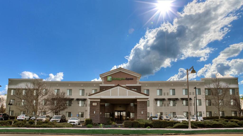 Holiday Inn Express Hotel & Suites Lincoln-Roseville Area, an IHG Hotel في روزفيل: مبنى مكتب مع الشمس في السماء