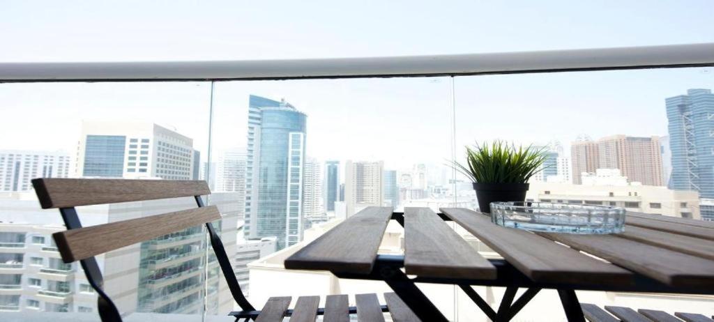 a wooden table and a chair on a balcony at Kaya Hostel in Dubai