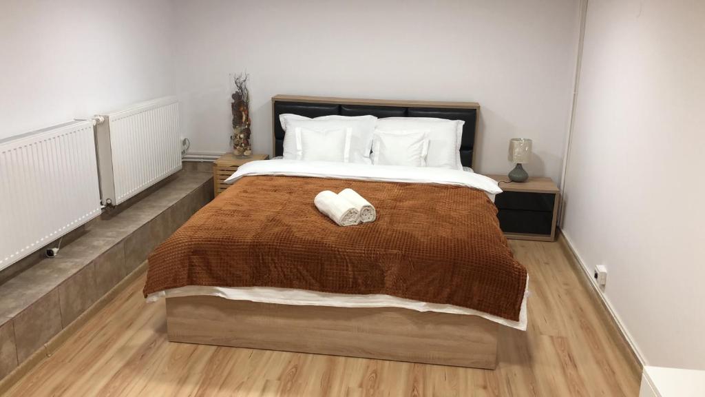 ein Schlafzimmer mit einem großen Bett mit einer braunen Decke in der Unterkunft gaby 2 in Braşov
