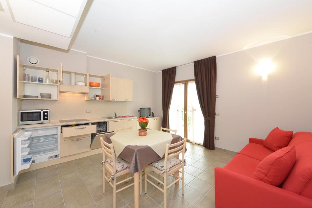 a living room with a table and a red couch at Agriturismo Al Palaz in Prata Camportaccio