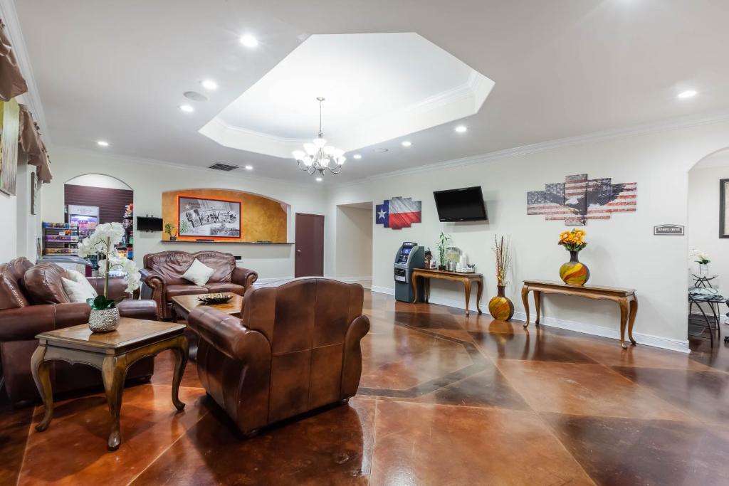 a living room with leather couches and tables at Super 8 by Wyndham Beaumont I-10 College St in Beaumont