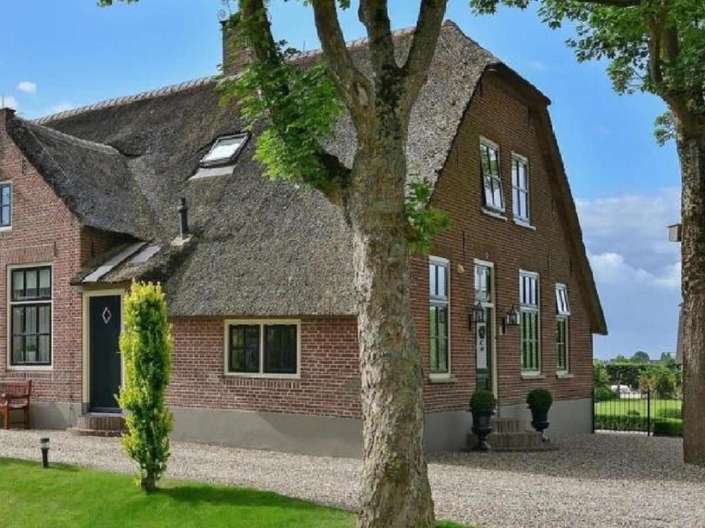 un gran edificio de ladrillo con techo gris en Magnificent farmhouse in Central Holland 4A & 2C, en Schoonrewoerd