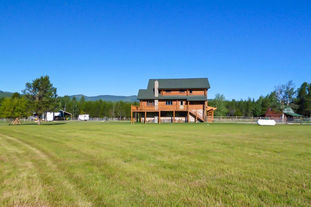 a large house in a field with a large yard at Waterfront Ranch on Pend Oreille in Sagle