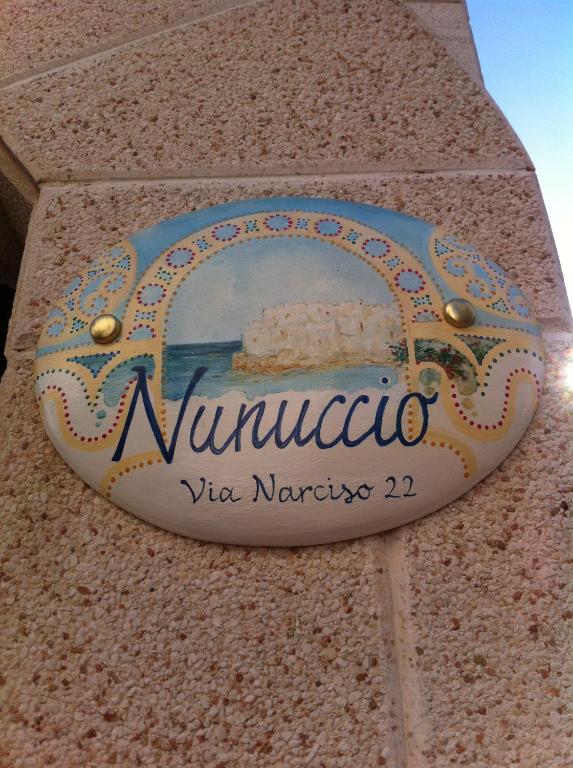 una señal en el costado de un edificio con una señal en él en Nunuccio - Locazione Turistica, en Polignano a Mare