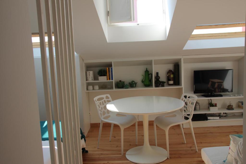 リスボンにあるLargo Trigueiros Light-Filled Loft Apartmentのダイニングルーム(白いテーブル、椅子付)