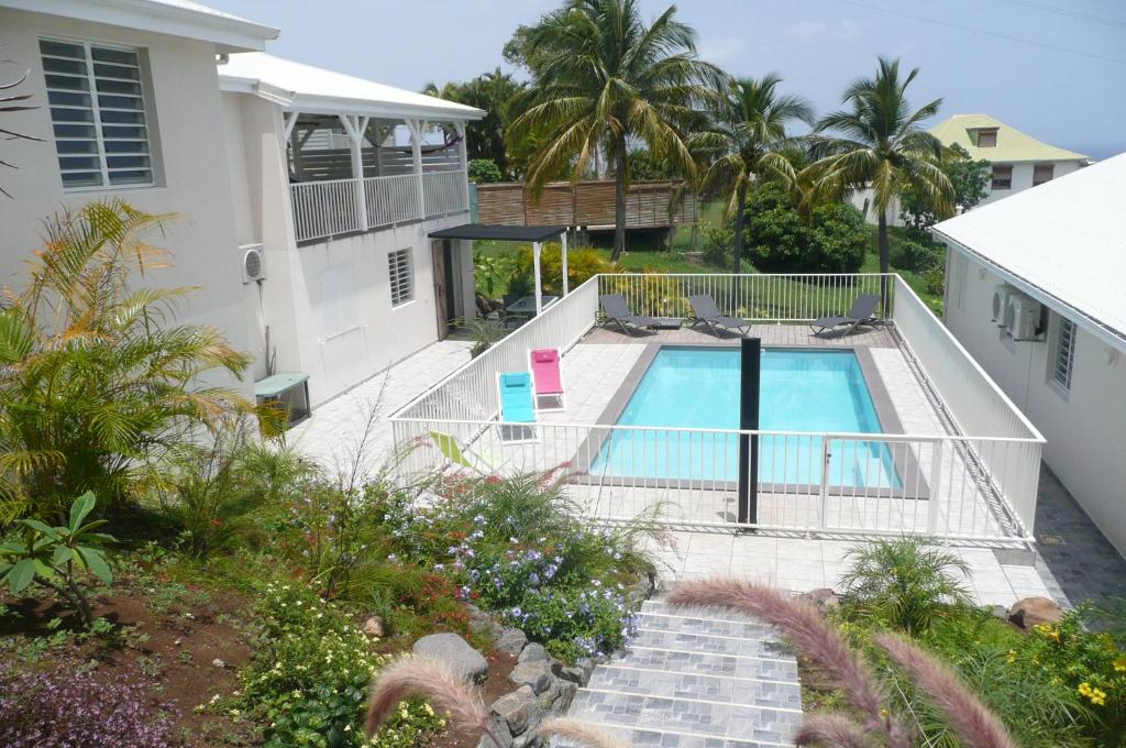 una casa con piscina en un patio en Douceurs Caraïbes, Gîte Coco., en Bouillante