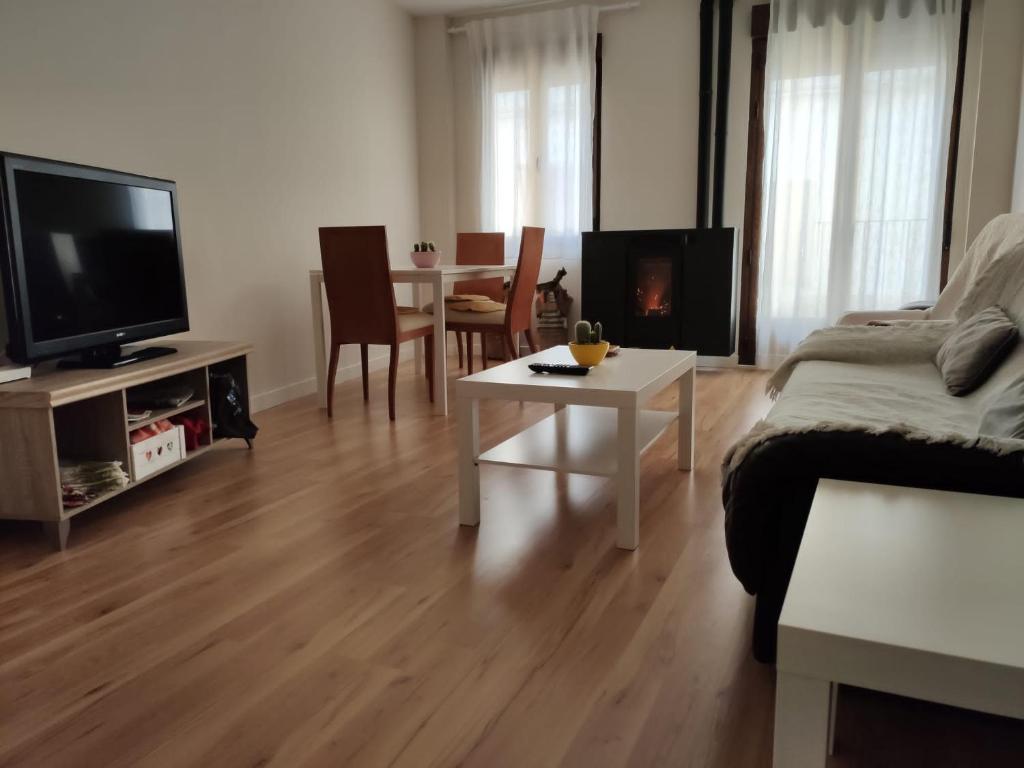 a living room with a couch and a table with a fireplace at Apartamento Nuevo Duplex in Santa Cruz de la Zarza