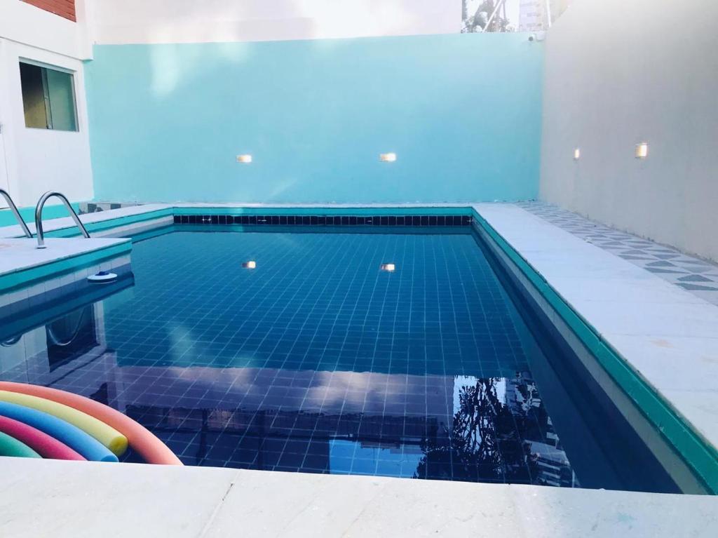una piscina con suelo de baldosa azul y azulejos azules en Apraiana Hostel, en Recife