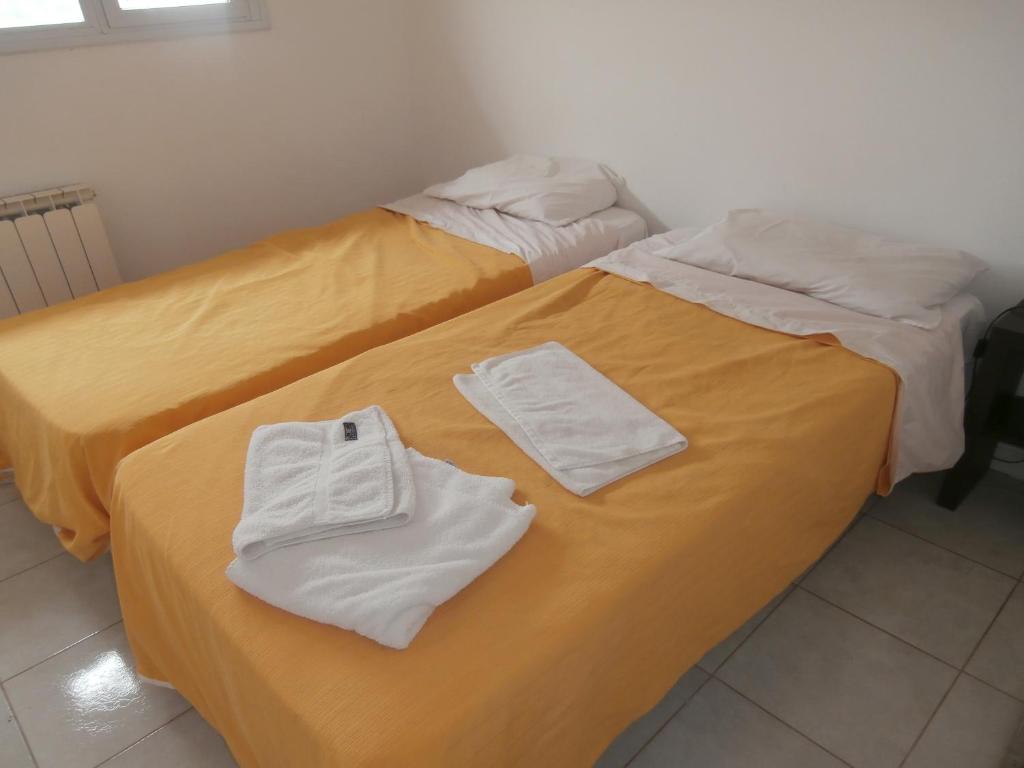 dos camas sentadas una al lado de la otra con toallas. en Apart 12 de Octubre 1028 en Bahía Blanca
