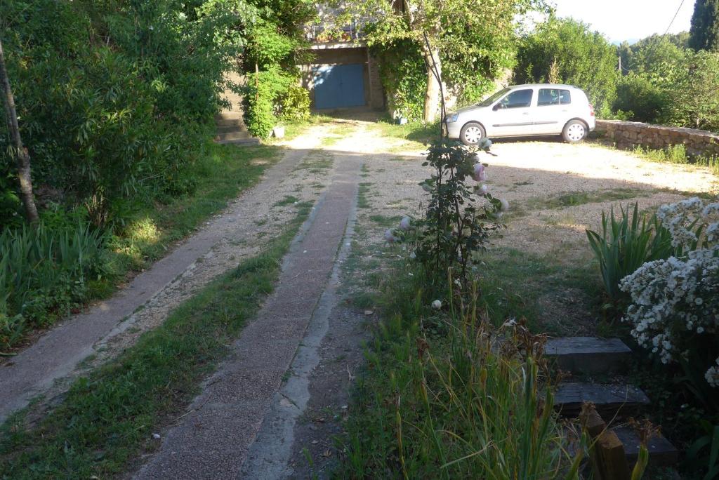 a road with a car parked in a yard at La Colline Bleue in Banne