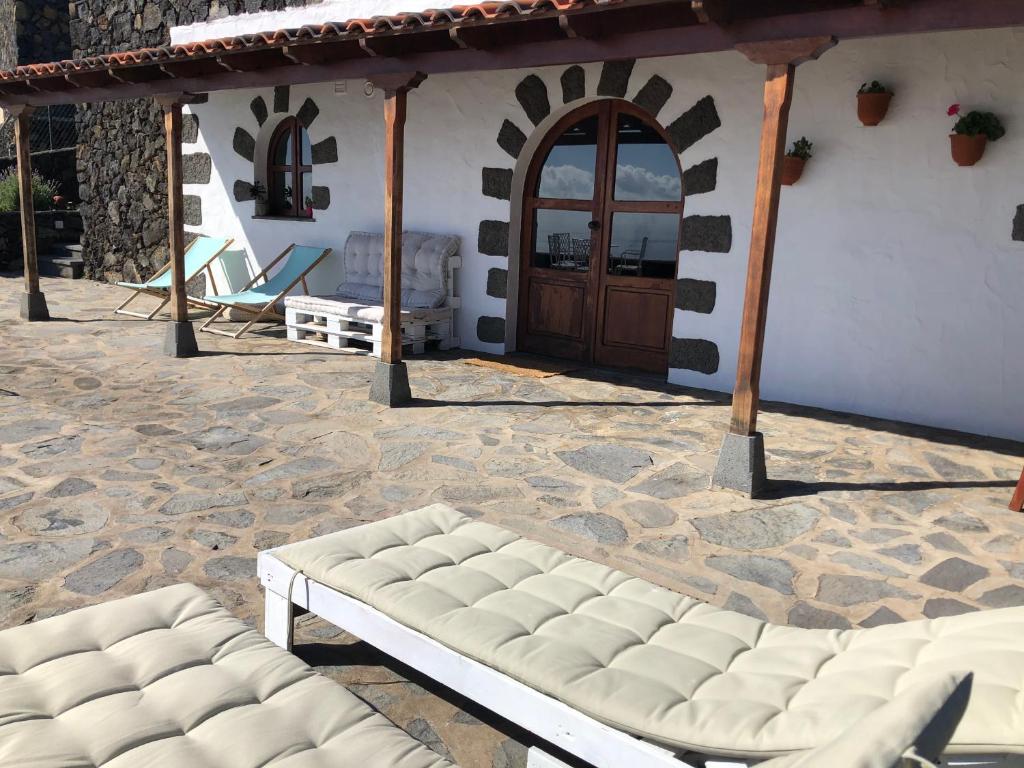 un patio con un sofá blanco frente a una casa en Villas Los Torres II en Fuencaliente de la Palma