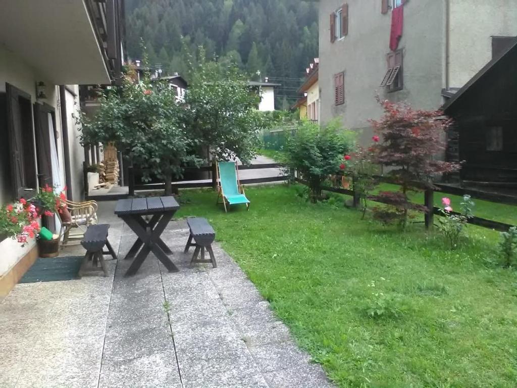 a patio with a picnic table and chairs in a yard at Casa Ognano (Pellizzano) in Pellizzano