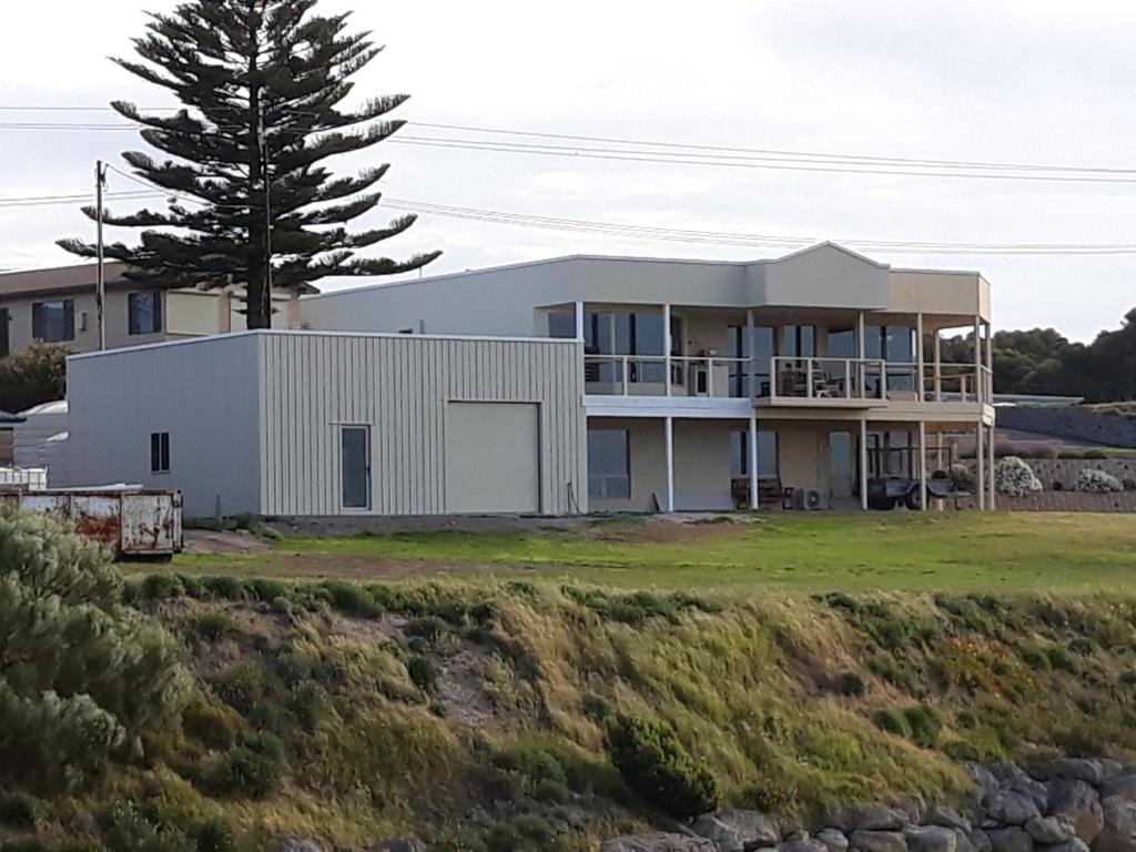 uma grande casa branca com uma árvore ao fundo em Costa Plenti Southend BnB em Southend