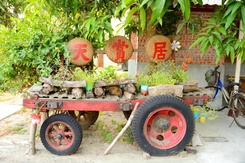 un carro rojo con plantas encima en Sky Gift Traditional Farm B&B, en Dongshi