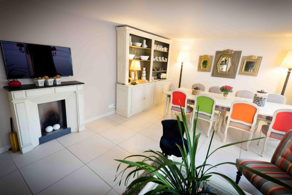 uma sala de estar com uma mesa e cadeiras e uma lareira em Champerret Heliopolis em Paris