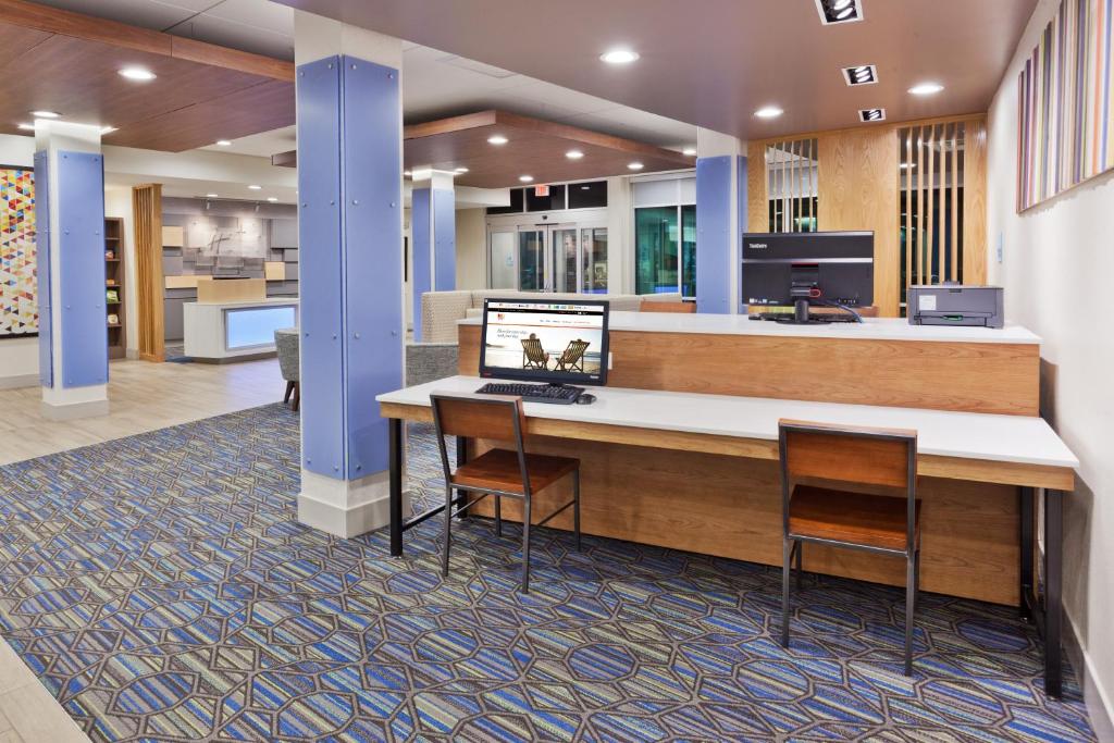 a lobby with a reception desk and two chairs at Holiday Inn Express & Suites - Cartersville by IHG in Cartersville