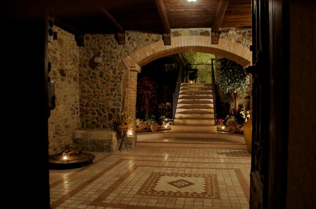 un ingresso a un edificio in pietra con arco e scale di Palazzo Conforti Tree House Resort a Marano Marchesato
