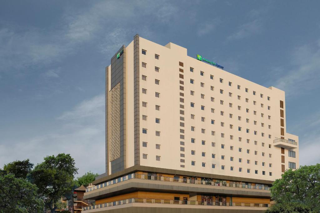 un gran edificio blanco con árboles delante de él en Holiday Inn Express Gurugram Sector 50, an IHG Hotel en Gurgaon