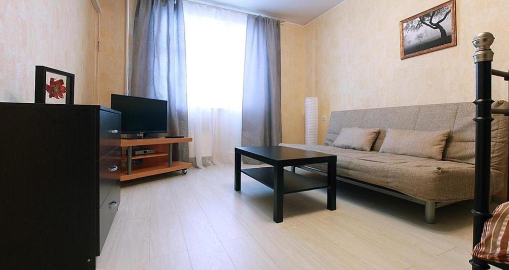 a living room with a couch and a table at ApartLux Yuzhnaya in Moscow