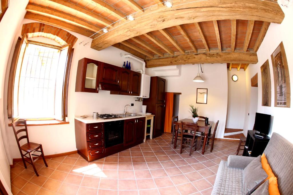 una cucina e un soggiorno con soffitto in legno di B&B Stradivari a Cremona