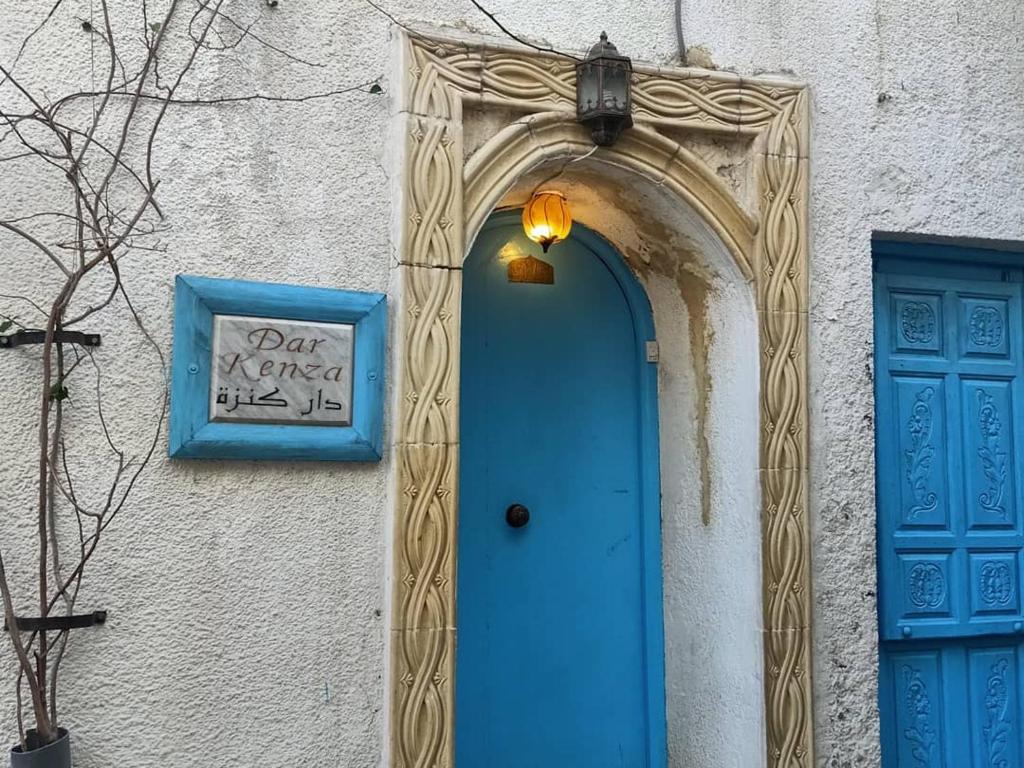 una puerta azul y una señal en el lateral de un edificio en Dar kenza Tunis en Túnez