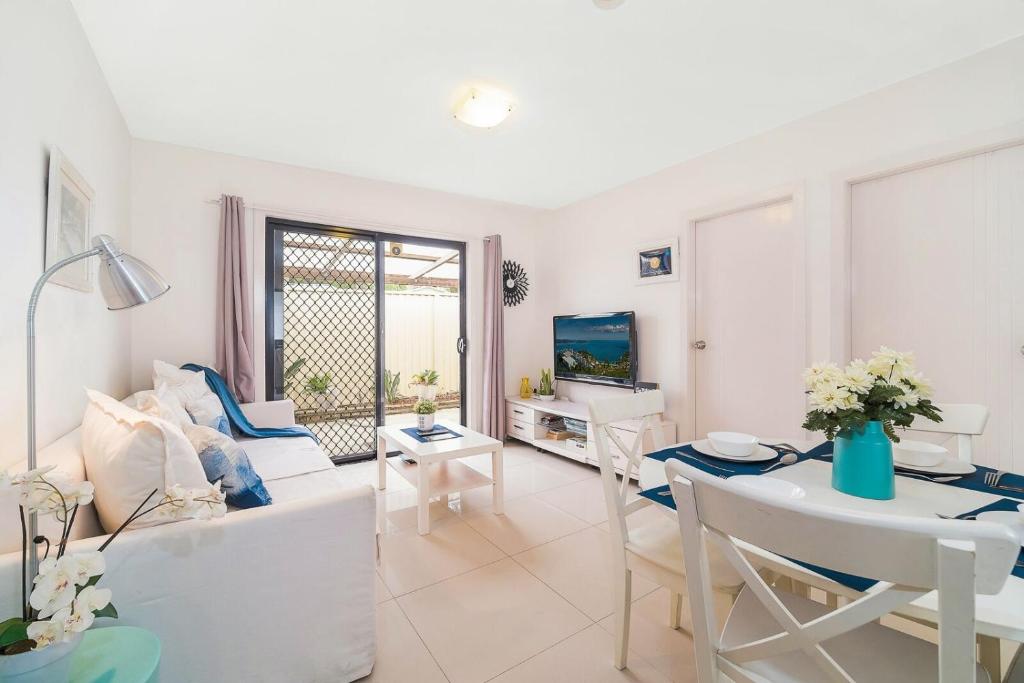 uma sala de estar com um sofá e uma mesa em 3 Bedrooms Holiday Home Near Sydney Airport em Sydney